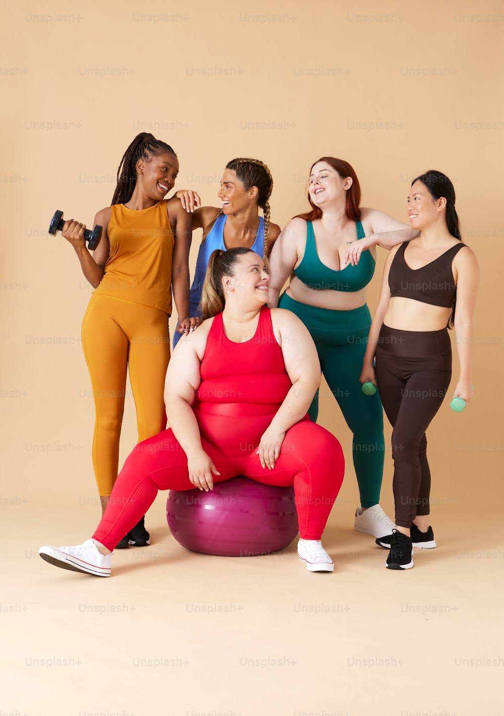 Un grupo de mujeres posando para una foto en una pelota de ejercicio
