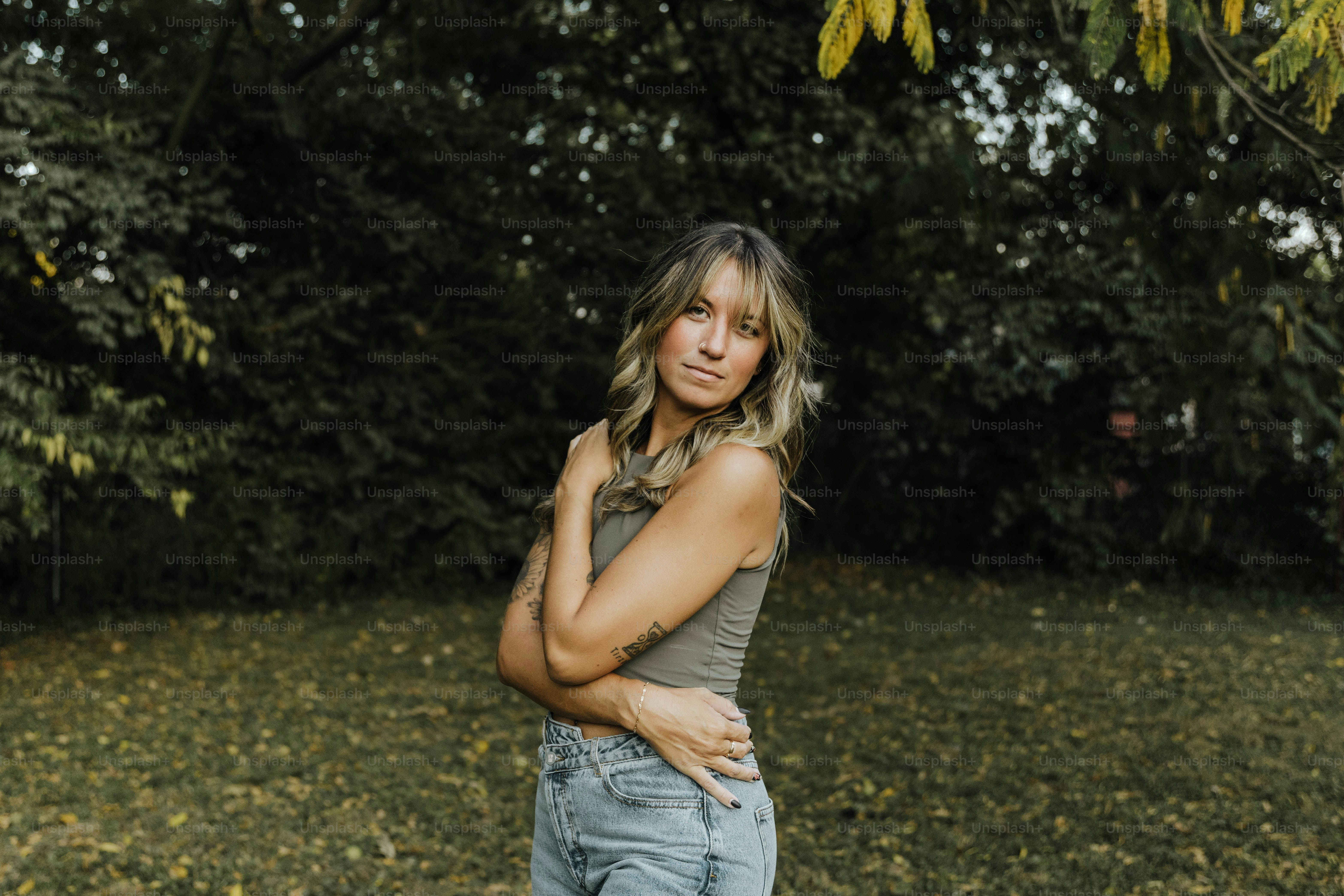 Une femme debout dans un champ, les bras croisés