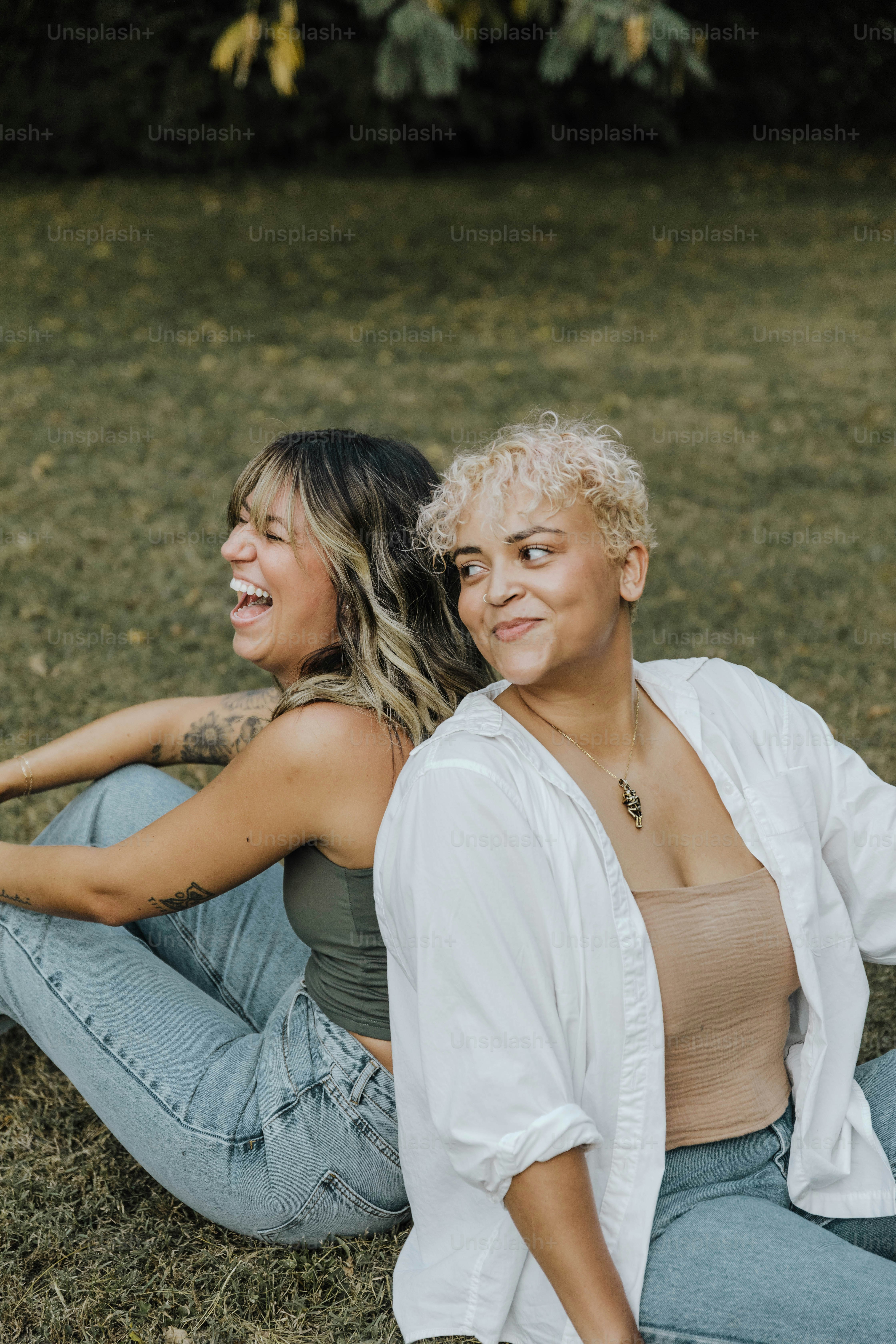 Ein paar Frauen, die auf einem grasbewachsenen Feld sitzen