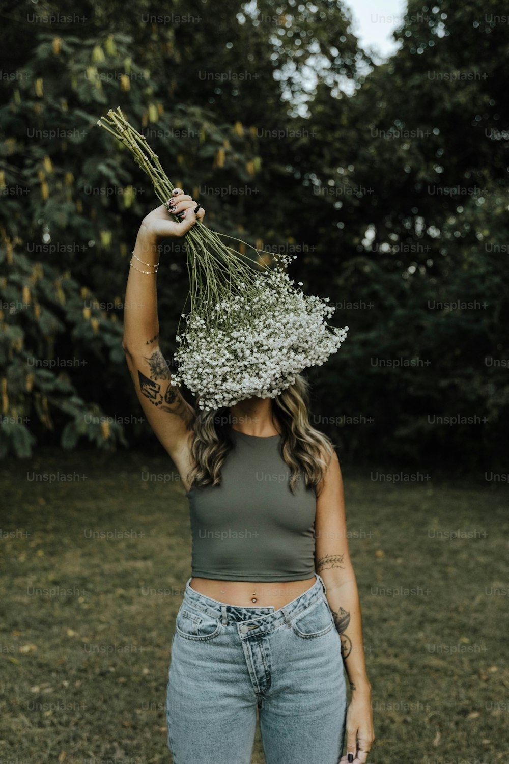 a woman holding a bunch of flowers on her head