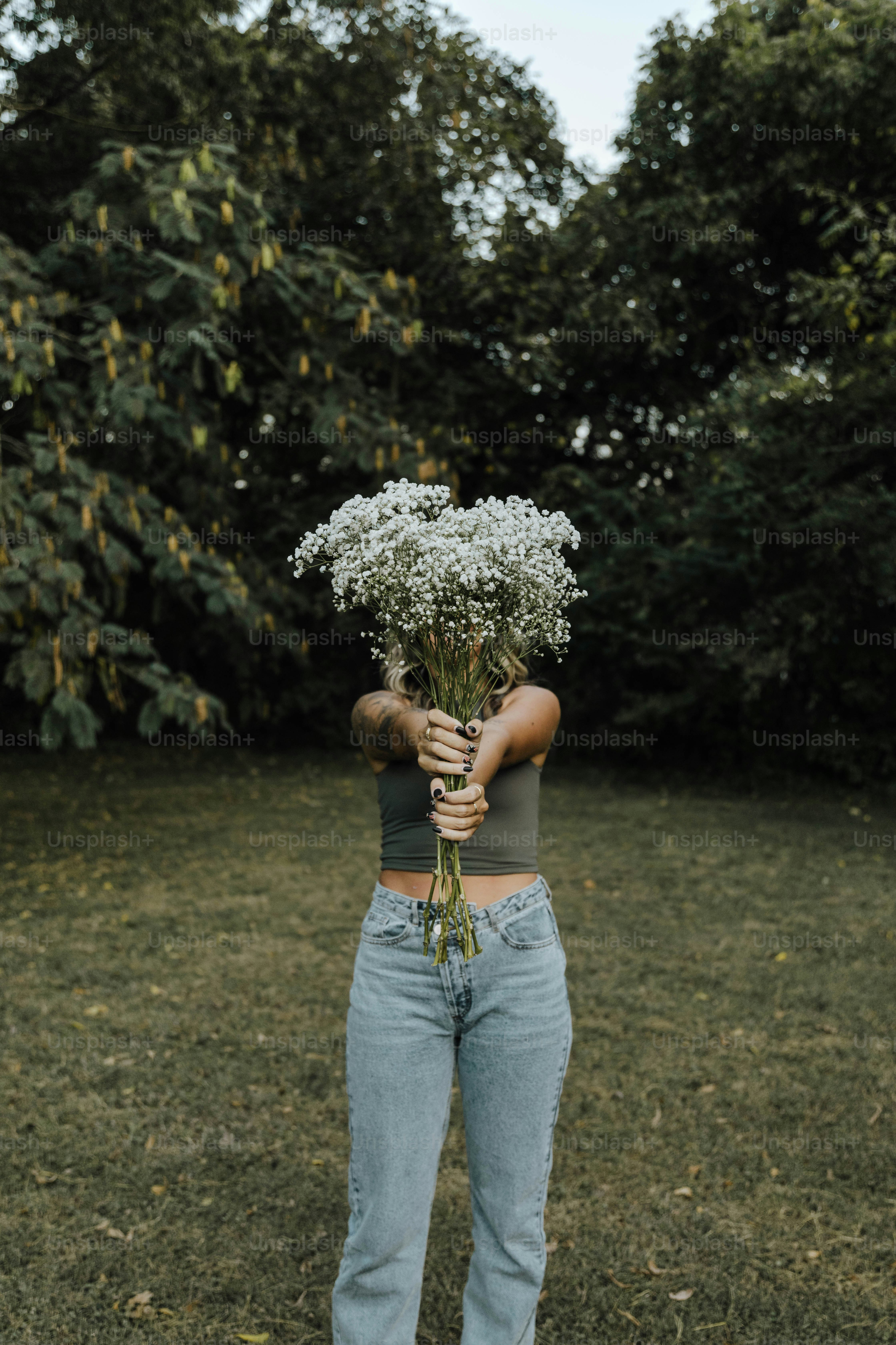 una donna che tiene un mazzo di fiori tra le mani