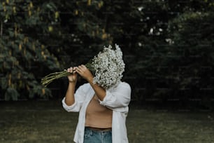 Eine Frau, die einen Blumenstrauß vor ihrem Gesicht hält