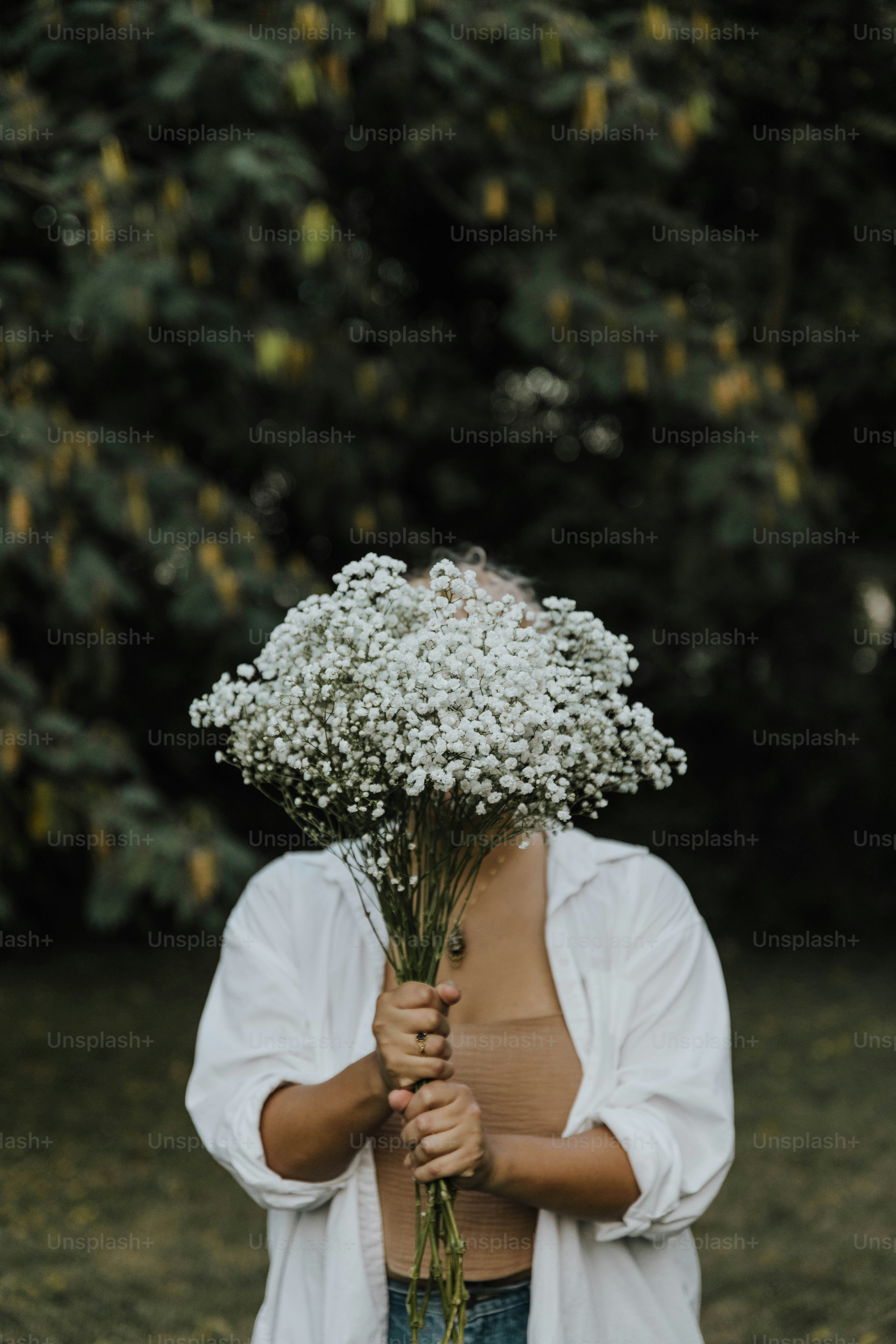 a woman holding a bunch of flowers in her hands