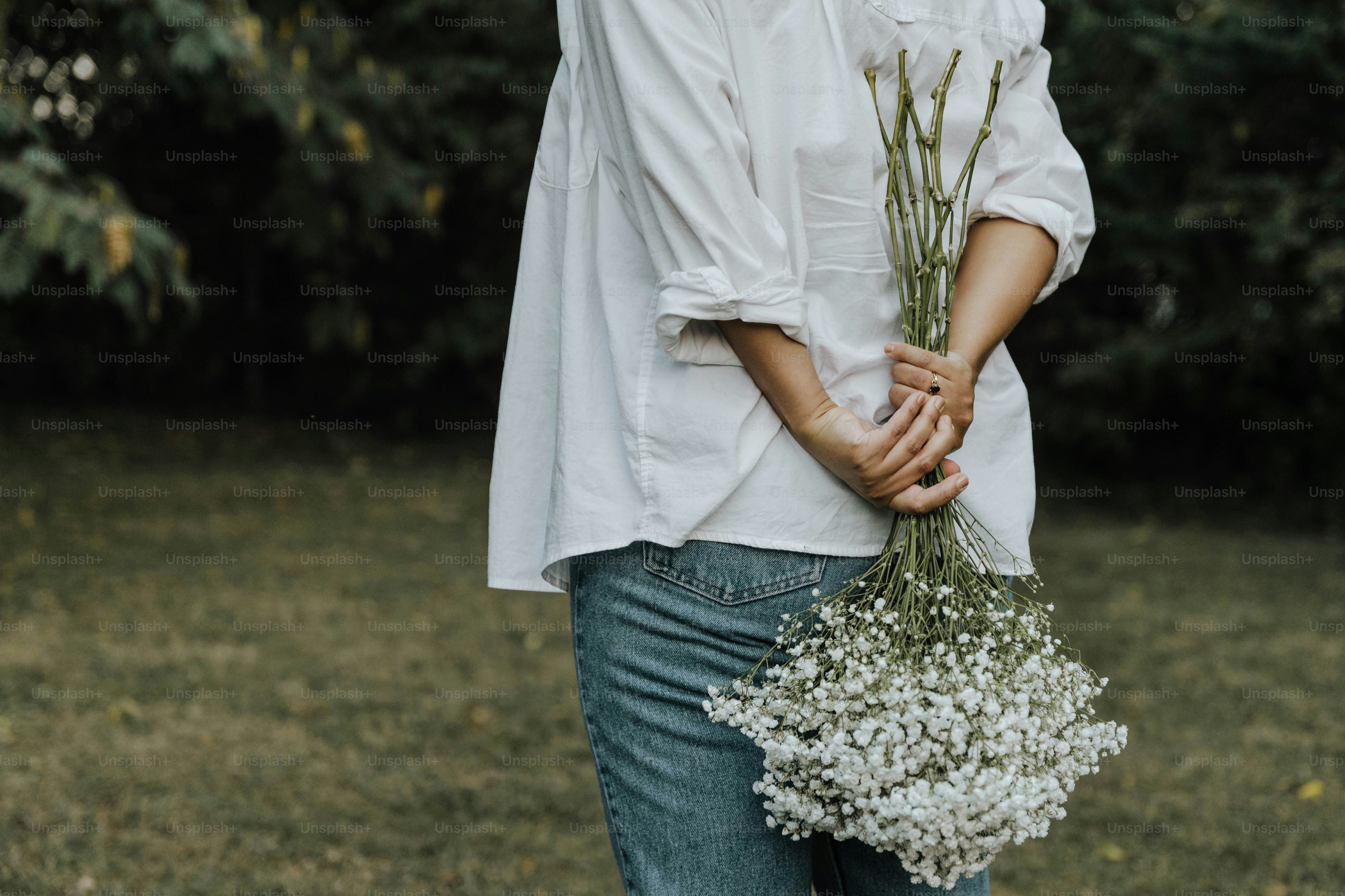 a woman holding a bunch of flowers in her hands