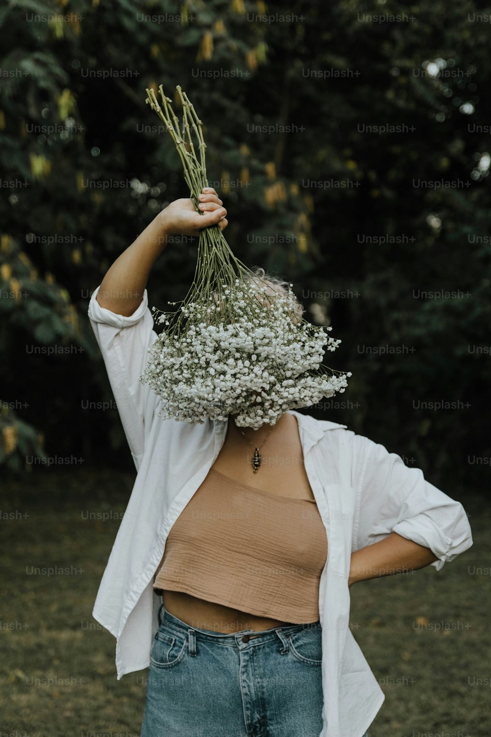 머리 위로 꽃다발을 들고 있는 여자