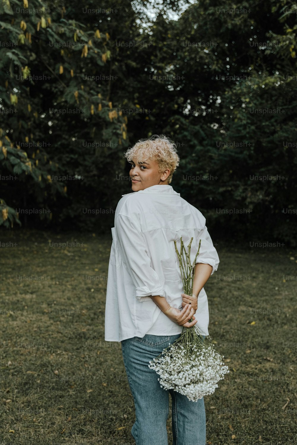 a woman holding a bunch of flowers in her hands