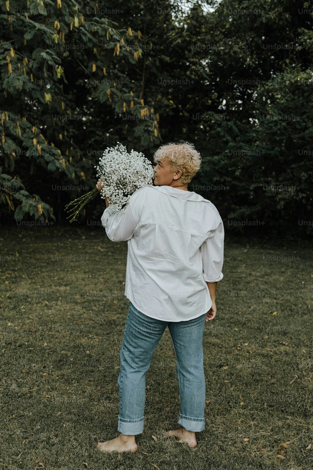 una donna in piedi in un campo con un mazzo di fiori