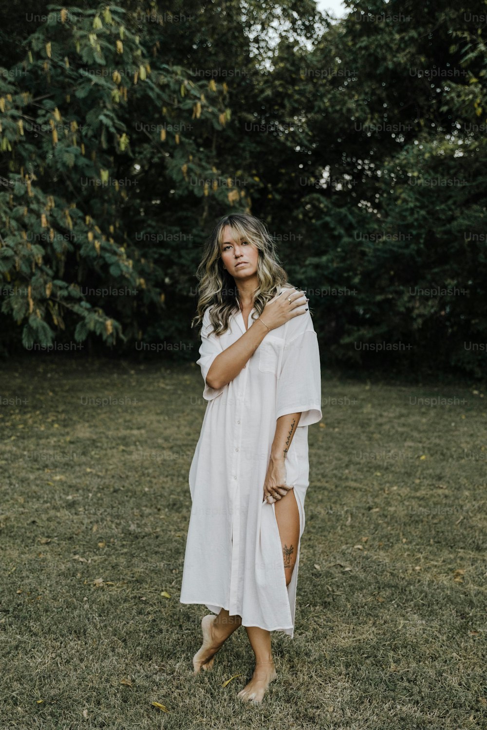 a woman in a white dress standing in a field