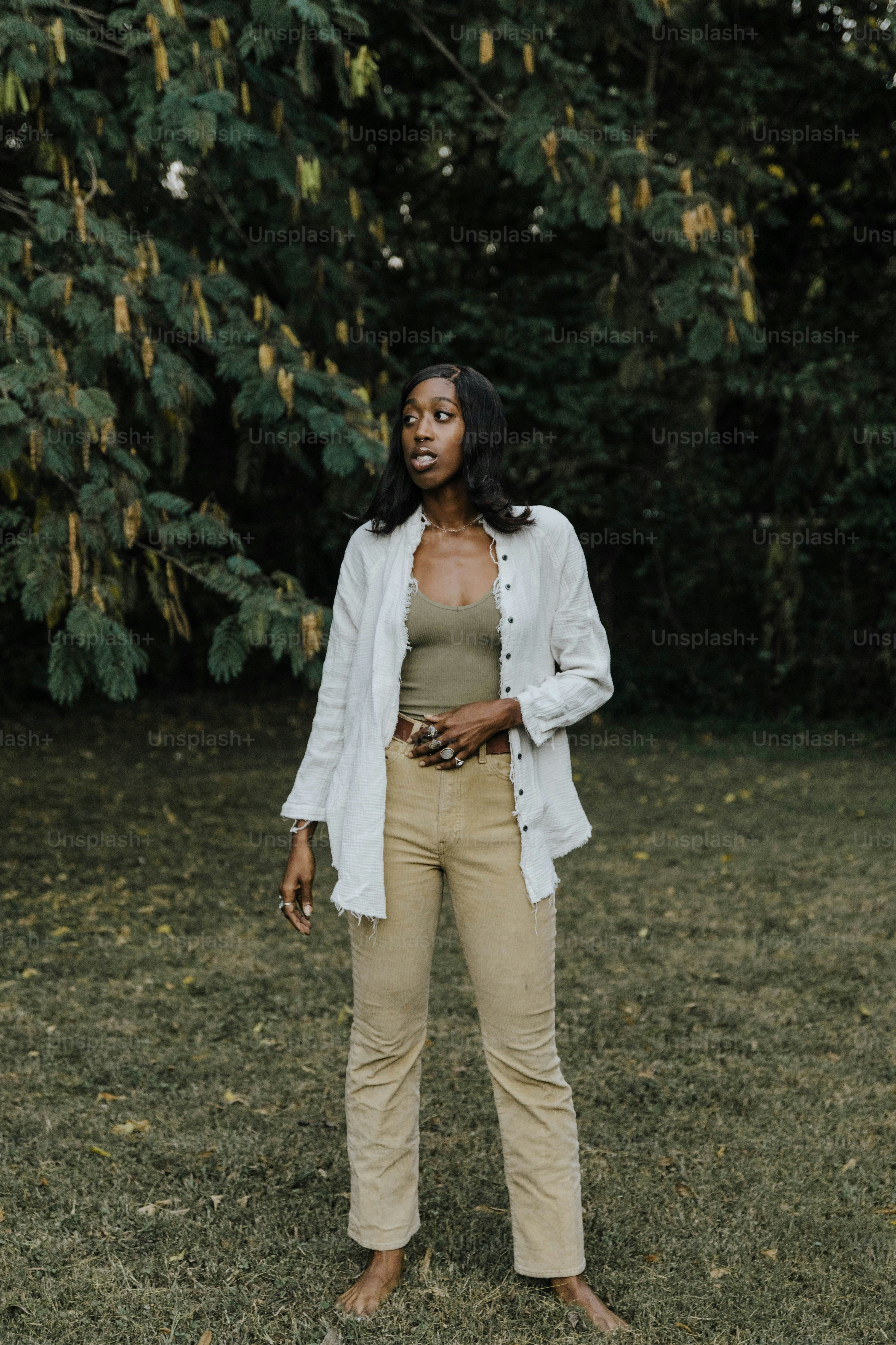Eine Frau, die auf einem Feld mit Bäumen im Hintergrund steht