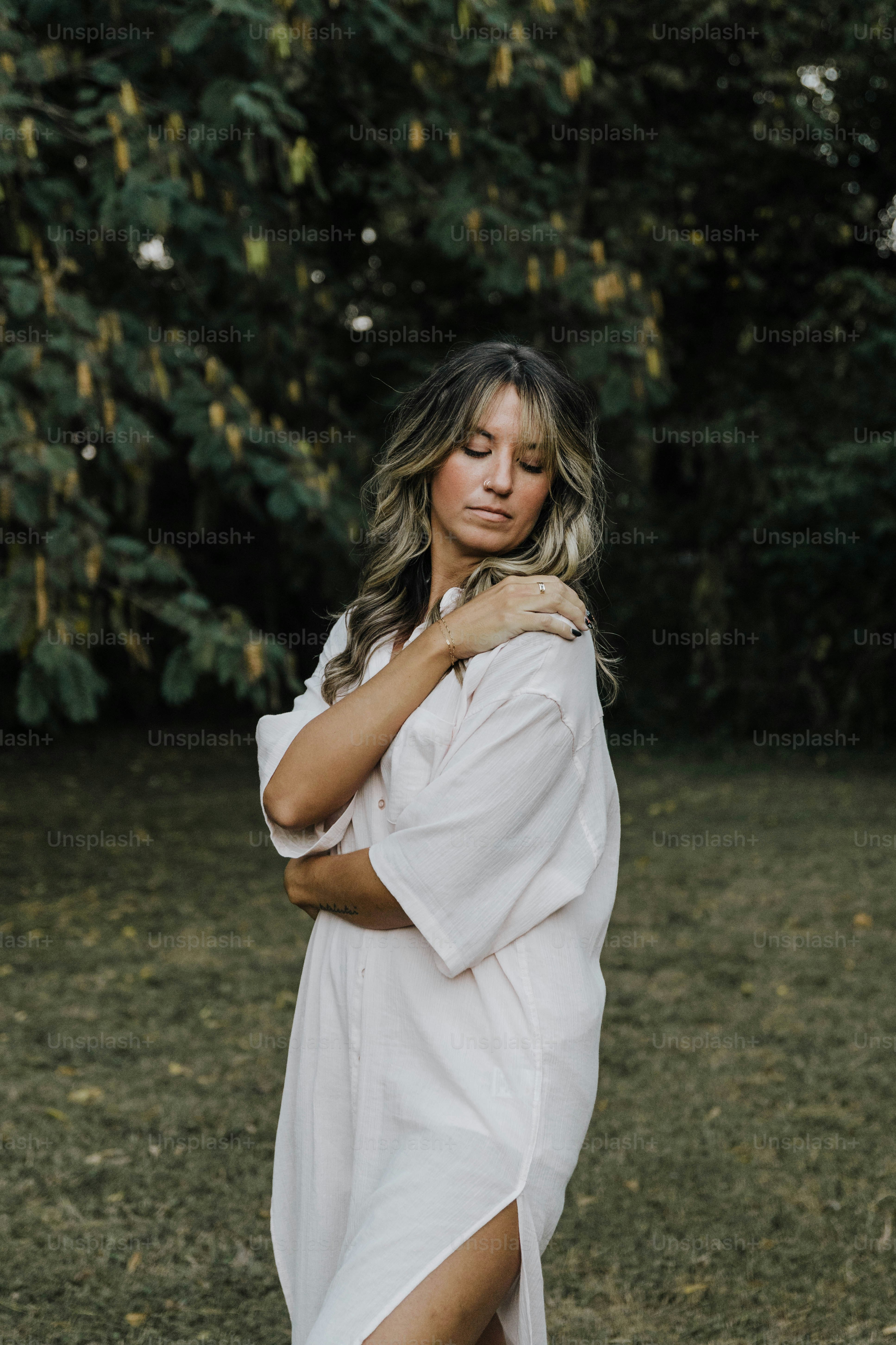 Eine Frau in einem weißen Kleid, die auf einem Feld steht