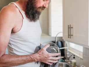 um homem com barba segurando um copo de água