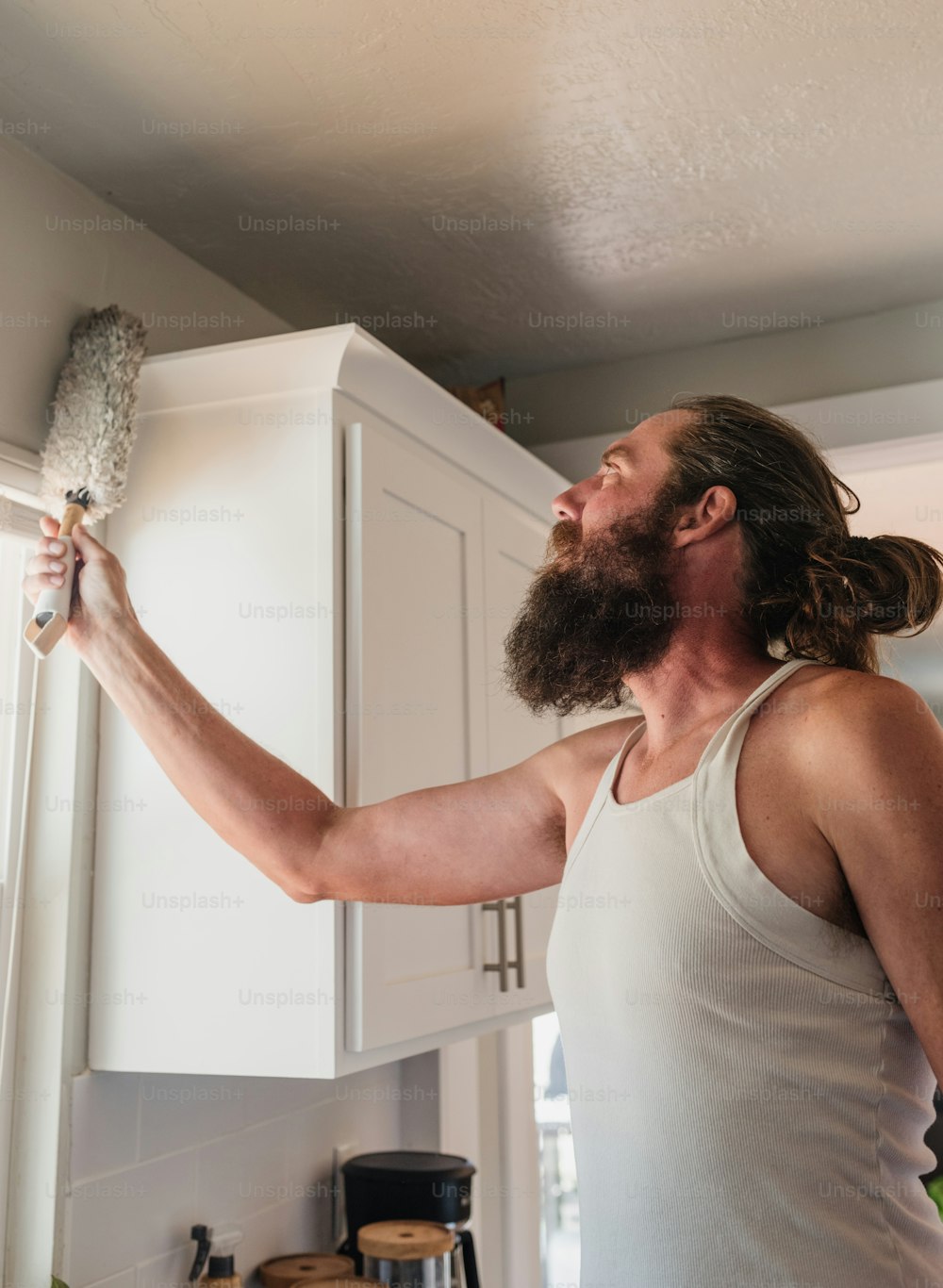 a man in a tank top is holding a brush