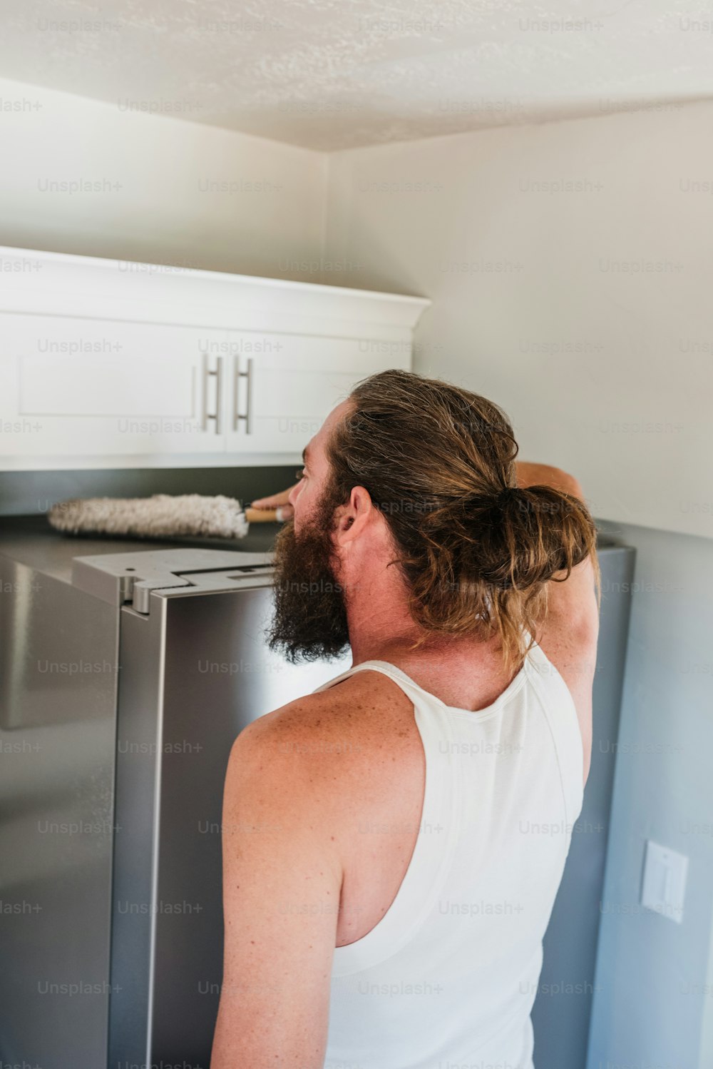 a man brushing his teeth in front of a refrigerator