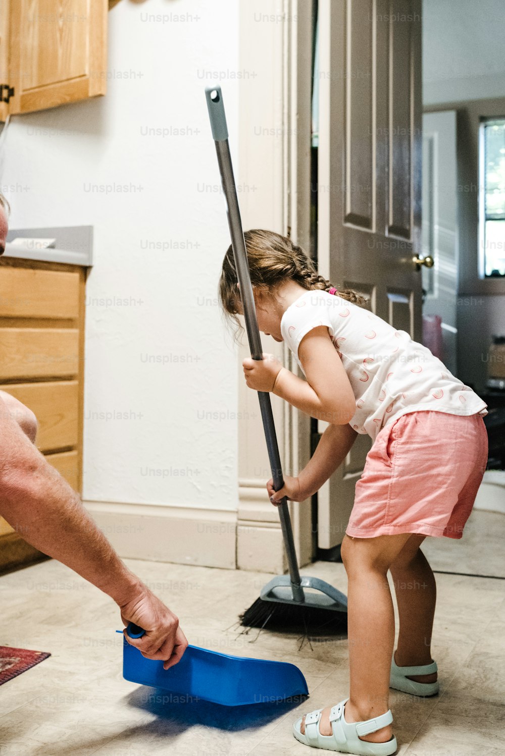 Un hombre y una niña están limpiando el piso