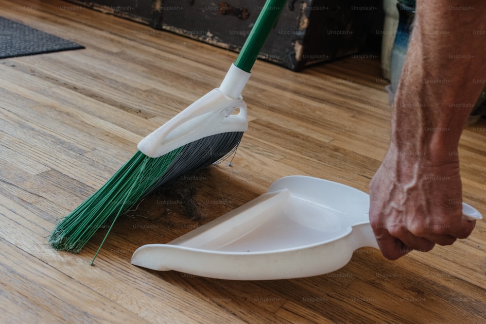 a person is cleaning a wooden floor with a mop