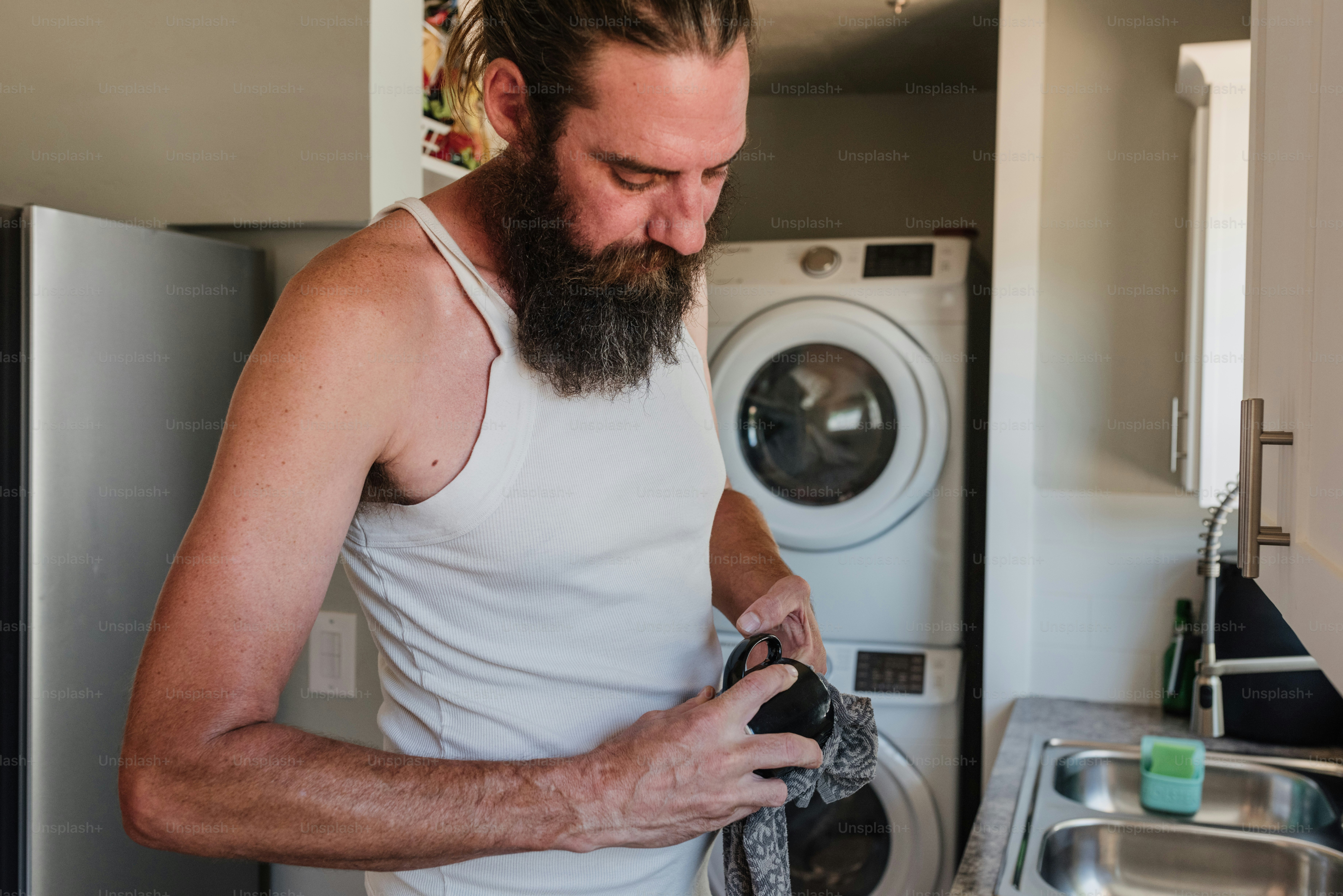 A man in a white tank top is holding a rag photo – Cleaning Image on ...