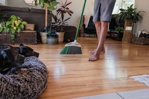 a dog laying on a dog bed while a person mop the floor