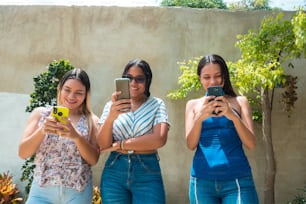 Three friends caught looking at a smartphone
