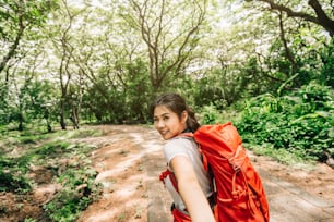 Happy smile young beautiful Asian woman leading you into forest for traveling