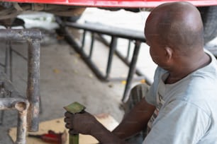 African mechanic working under the vehicle in a workshop.