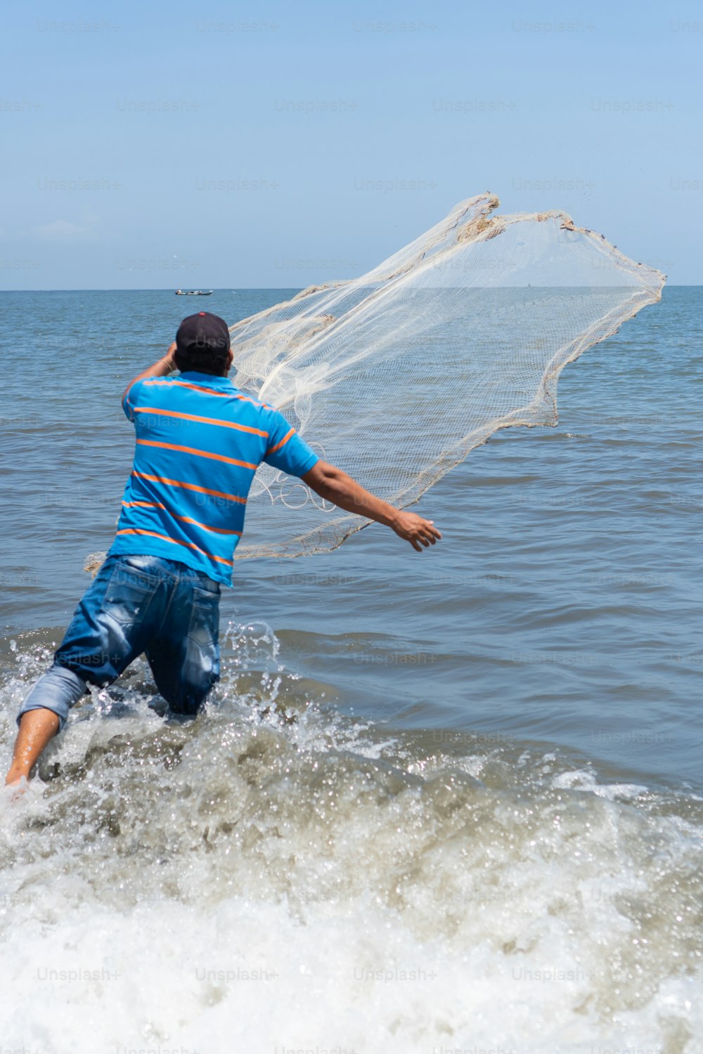 Pêcheur sur la plage lançant un filet de pêche