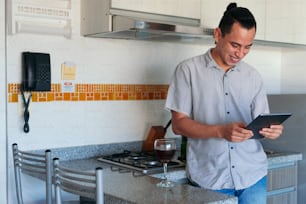 Man using a tablet in his home kitchen