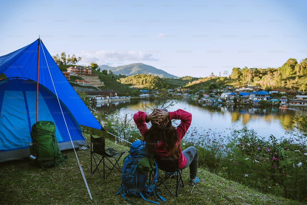 Asian woman travel nature. Travel relax, Camping in a rural village on the mountain, near the lake.
