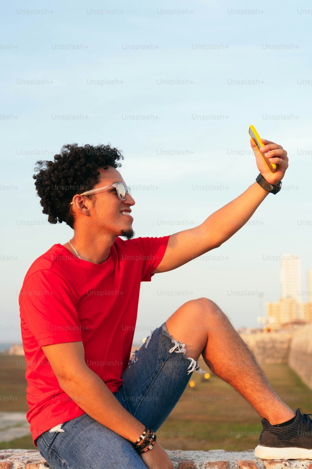 Curly-haired man taking a selfie in the open air