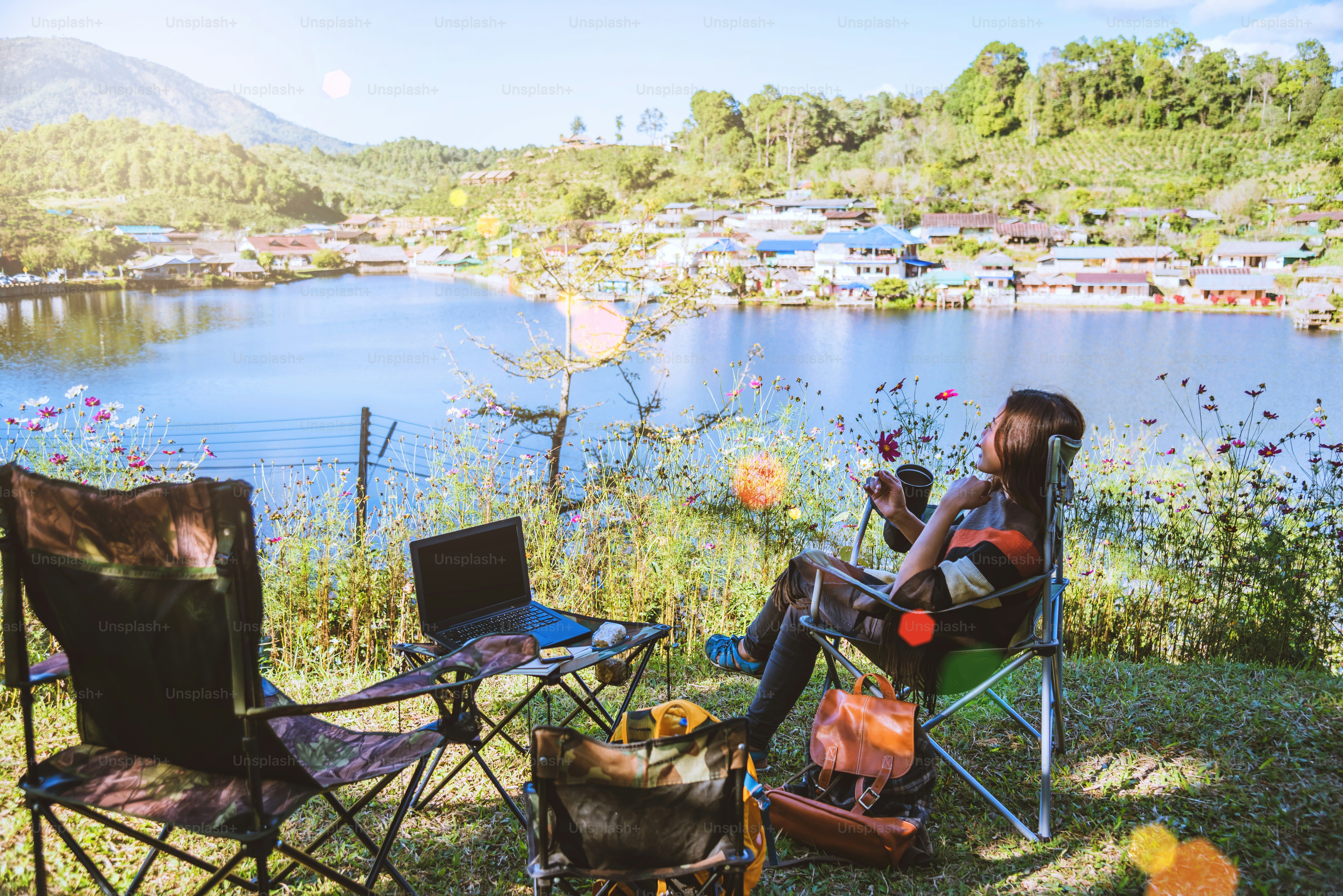 Asian female tourists camping and And working notebook, She is happy, relaxed, enjoying reading a book.