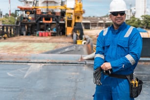 Marine Deck Officer or Chief mate on deck of offshore vessel or ship, wearing PPE personal protective equipment - helmet, coverall