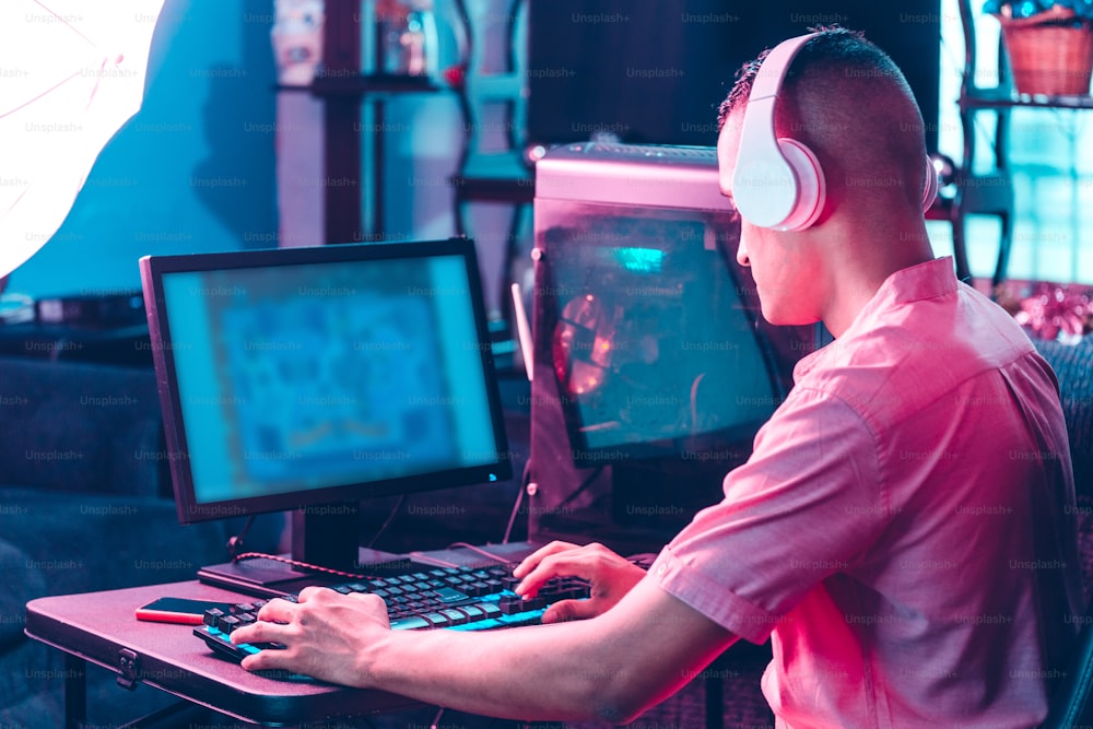 Hombre trasero del hombre del jugador jugando en una computadora.