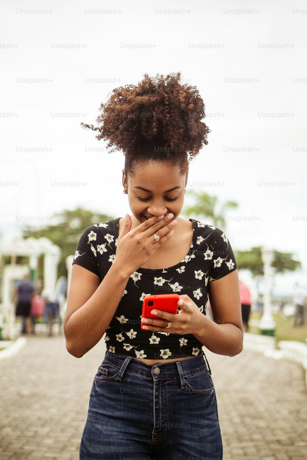Portrait of african woman making gesture of surprise while using smartphone.