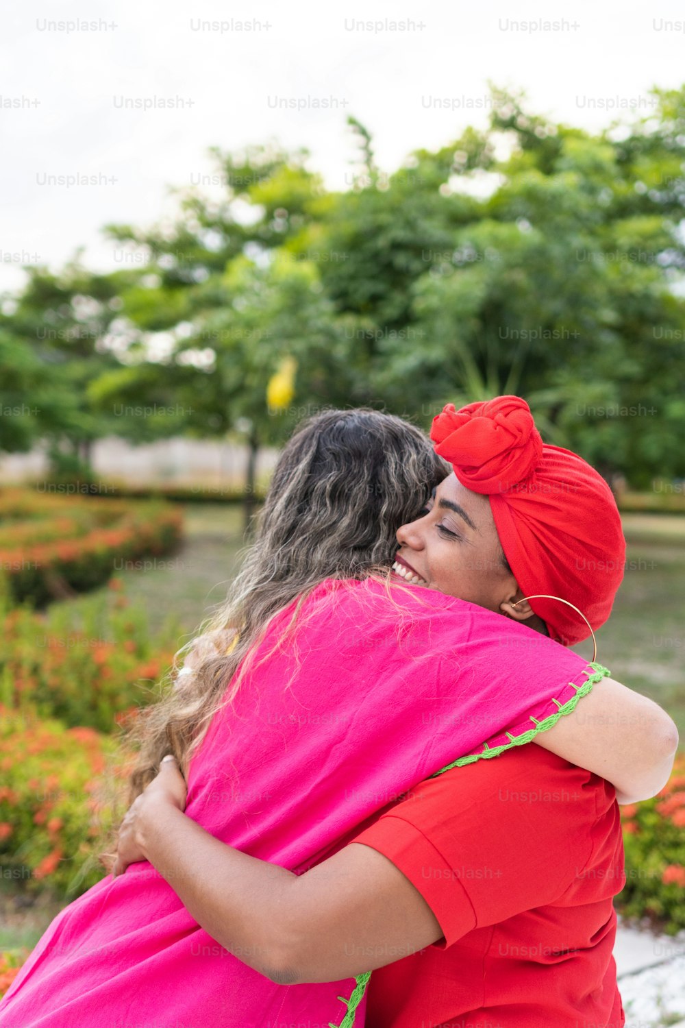 Two Latin women embrace each other in city park