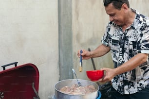 屋外のグリルで料理を調理するOderの男性
