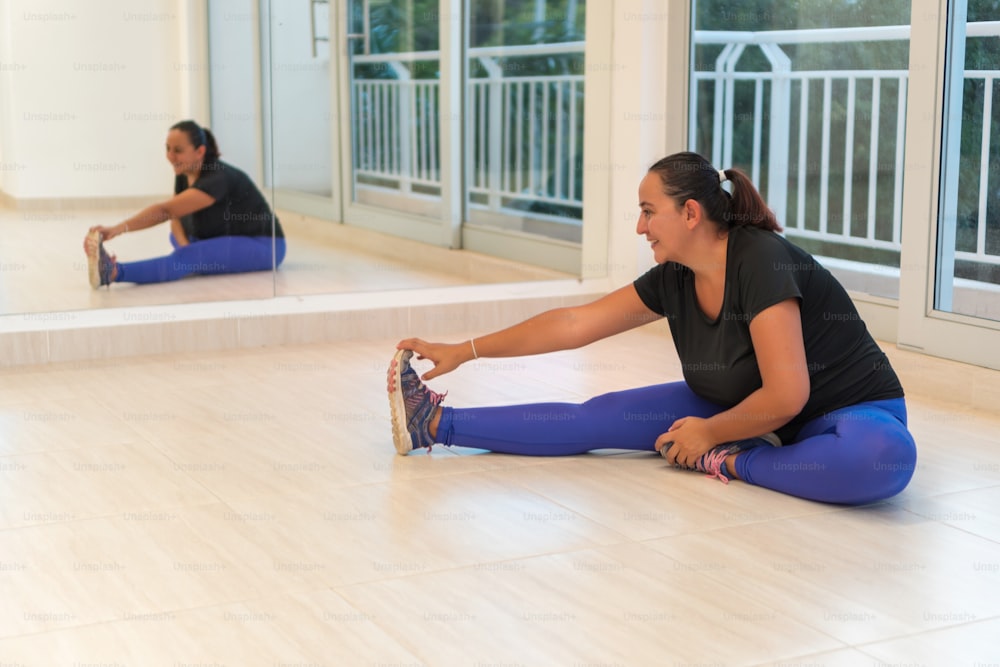 Uma jovem mulher hispânica que faz yoga em casa