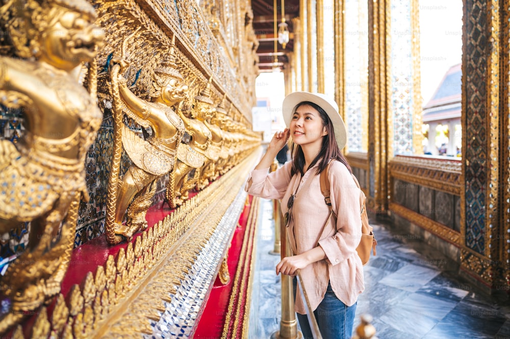 La mujer asiática turista disfruta de la visita turística mientras viaja en el templo del Buda de Esmeralda, Wat Phra Kaew, lugar turístico popular en Bangkok, Tailandia