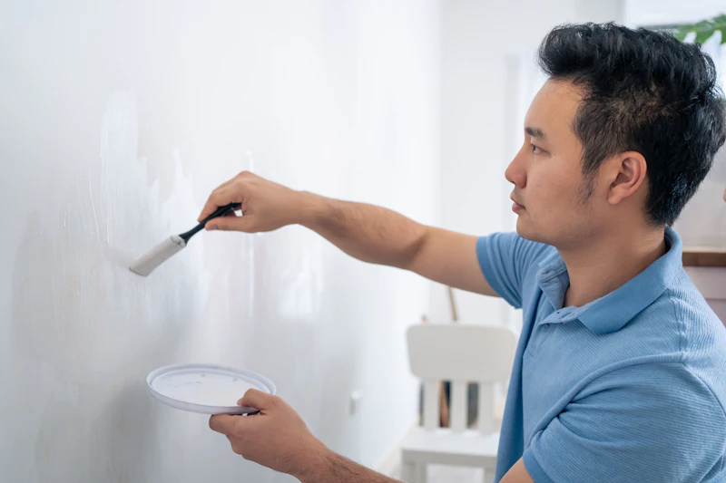 Painter brushing wall