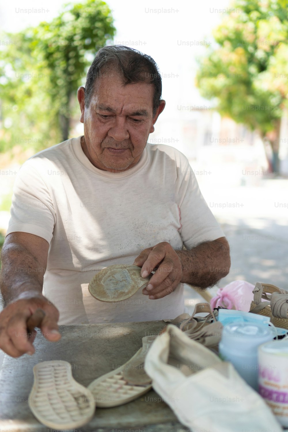 Latin man mending shoes in the open air
