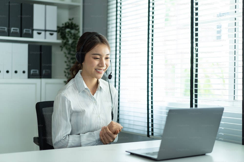 면접을 위해 HR 관리자와 아시아 아름다운 여성 화상 통화. 아름다운 소녀는 가상 온라인 회의에 노트북 컴퓨터를 사용하여 직장인 남자에게 이력서를 보여 주어 직장에 일자리를 신청합니다.