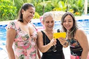 Latin women taking selfie by the pool