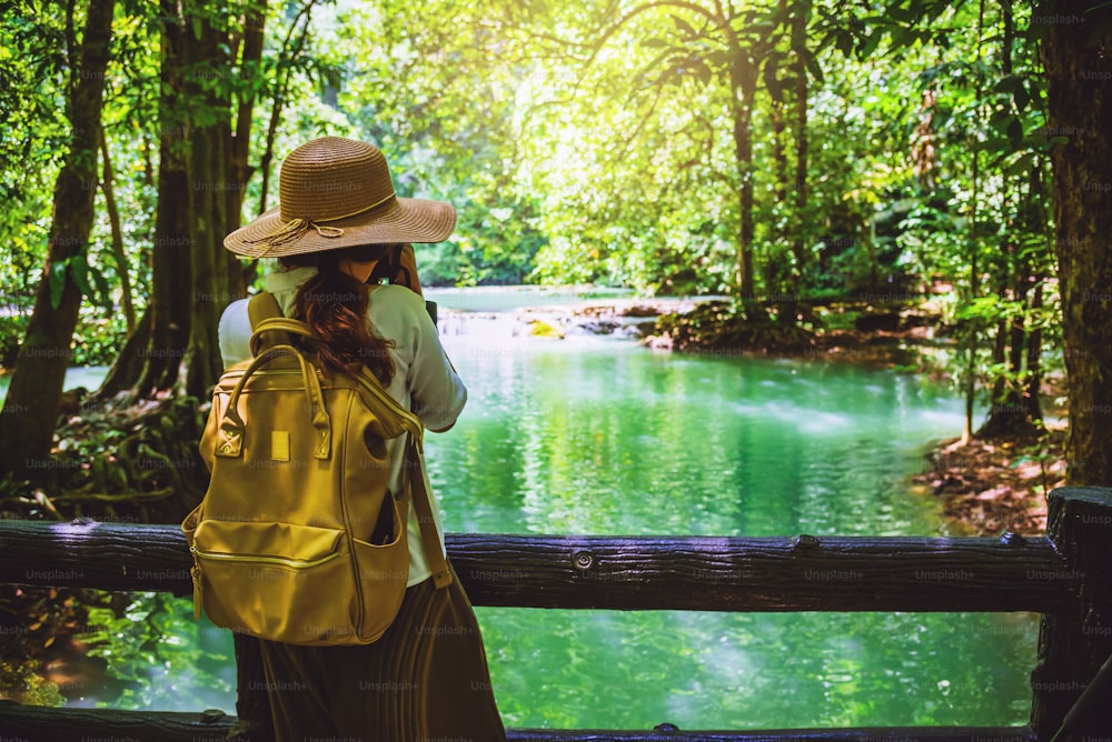 女の子はタンボックソーニ滝国立公園の写真を撮ります。湖、マングローブ林。自然を旅する。リラックスした旅。旅行タイ、バックパック、スタイル、森、夏。