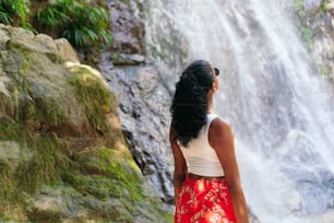 woman at the bottom of a tropical waterfall. Vacation concept