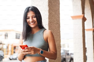 Young latin american woman using smartphone.