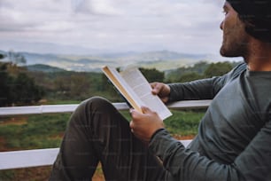 Homem viajante está lendo livro viaja natureza na montanha No ar fresco no norte, Chiang Mai, na Tailândia.