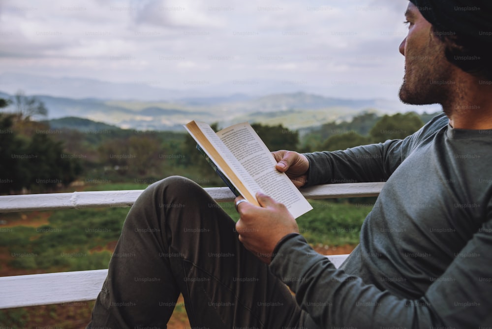 Man traveler is reading book travels nature on the mountain In the fresh air in the north, Chiang Mai in Thailand.