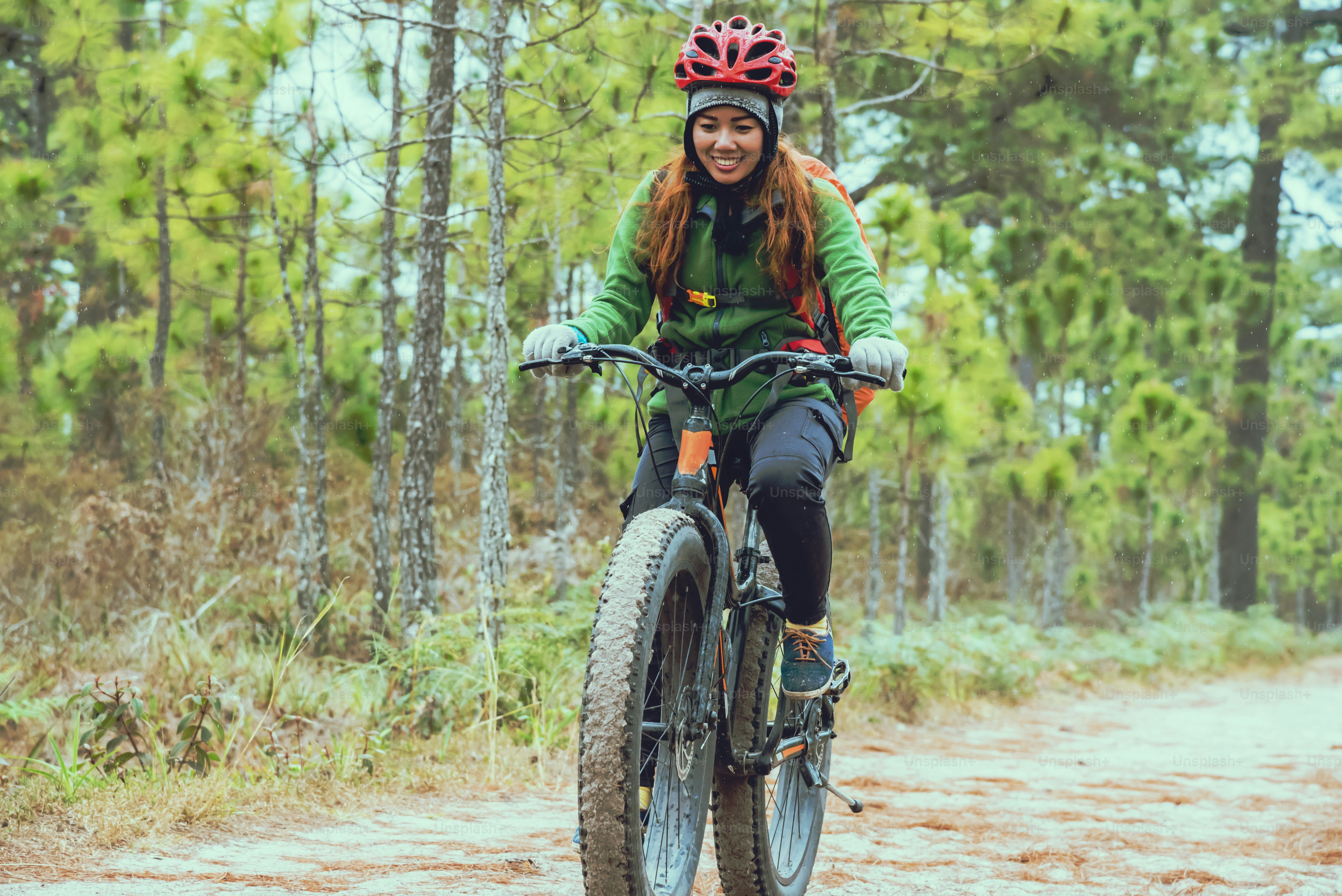 women on bike riding through mud