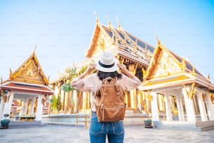 Vista trasera de la mujer turista disfruta del viaje en el templo del Buda de Esmeralda, Wat Phra Kaew, popular lugar turístico en Bangkok, Tailandia