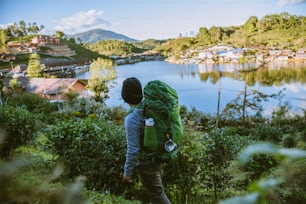 아시아 남자는 자연을 여행합니다. 여행 휴식, 호수 근처의 산에있는 시골 마을에서 캠핑.