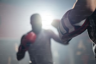 L’entraîneur de fitness actif enseigne et motive les jeunes sportifs afro-américains à s’entraîner, à faire de l’exercice en faisant de la boxe ou du muay thaïlandais. Boxeur Athlète combattant portant un gant, pratiquant le coup de poing pour entraîner au club de gym.