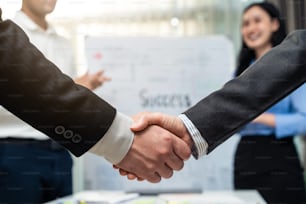 Close up hands of businessman and woman handshake after negotiations for Business deal, merger and acquisition in meeting room. Office worker clap hand, enjoy success partnership agreement in company.